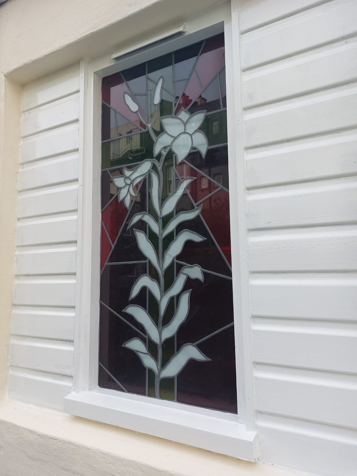 A new coat of paint applied to an exterior, without touching the beautiful stained glass